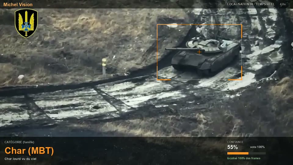 Le même char sombre sur terrain brûlé, encadré en orange avec un réticule en son centre.